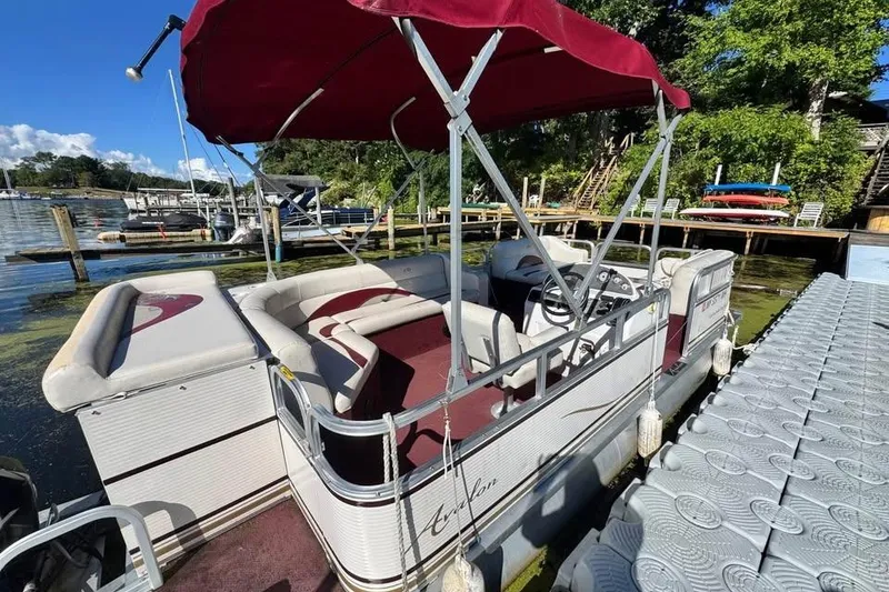 Slide: The Image of 2008 Avalon Catalina 18' pontoon boat docked with red canopy and seating. - 8