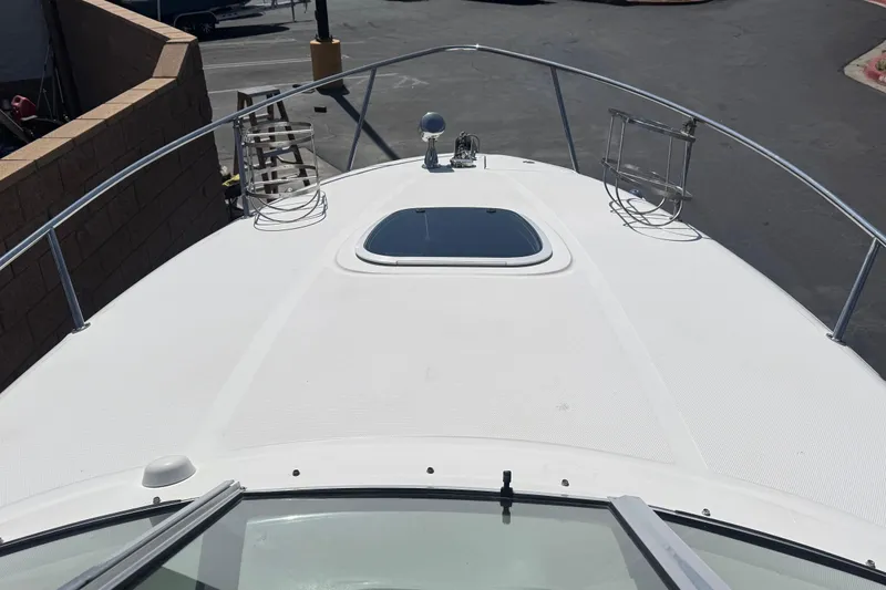 Slide: The Image of 2006 Sea Ray Sundancer 260 boat deck with hatch and railing in a parking area. - 10