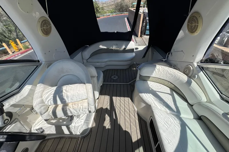 Slide: The Image of Interior of a 2006 Sea Ray Sundancer 260 boat with white seating and wood flooring. - 11