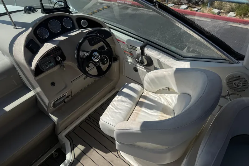 Slide: The Image of 2006 Sea Ray Sundancer 260 helm with steering wheel and white captain's chair. - 18