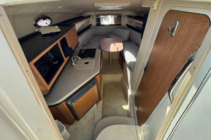 Slide: The Image of Interior of 2006 Sea Ray Sundancer 260 boat with kitchenette and seating area. - 24