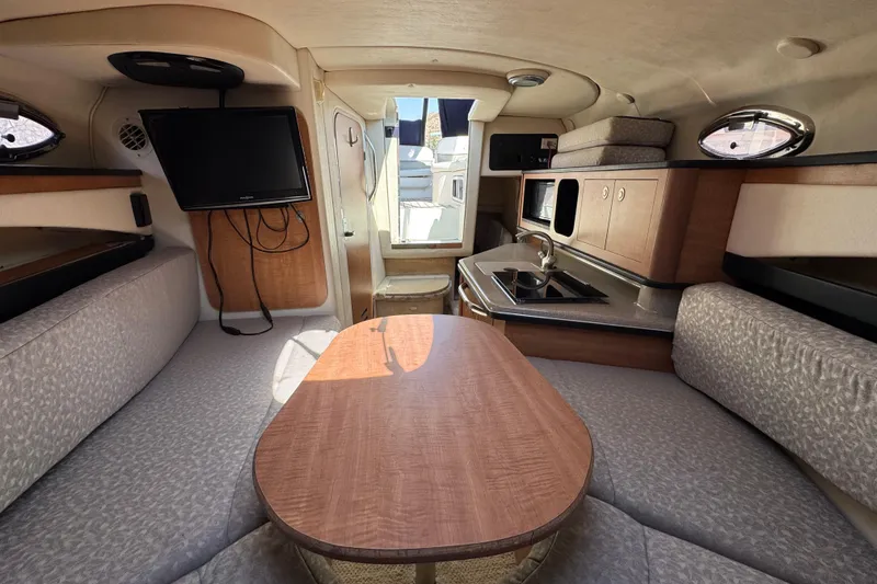 Slide: The Image of Interior of 2006 Sea Ray Sundancer 260 with kitchenette, seating, and TV. - 25
