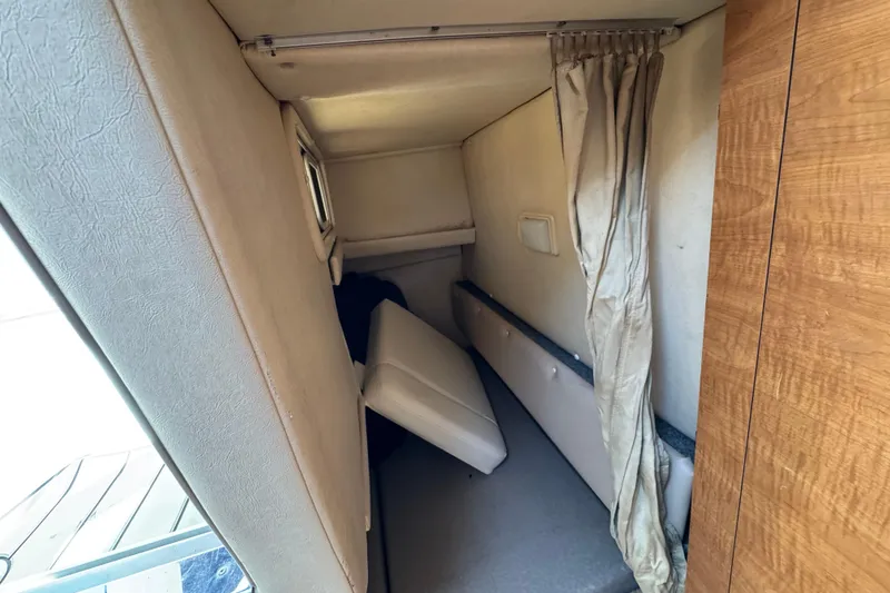 Slide: The Image of 2006 Sea Ray Sundancer 260 cabin interior with beige upholstery and wooden accents. - 27