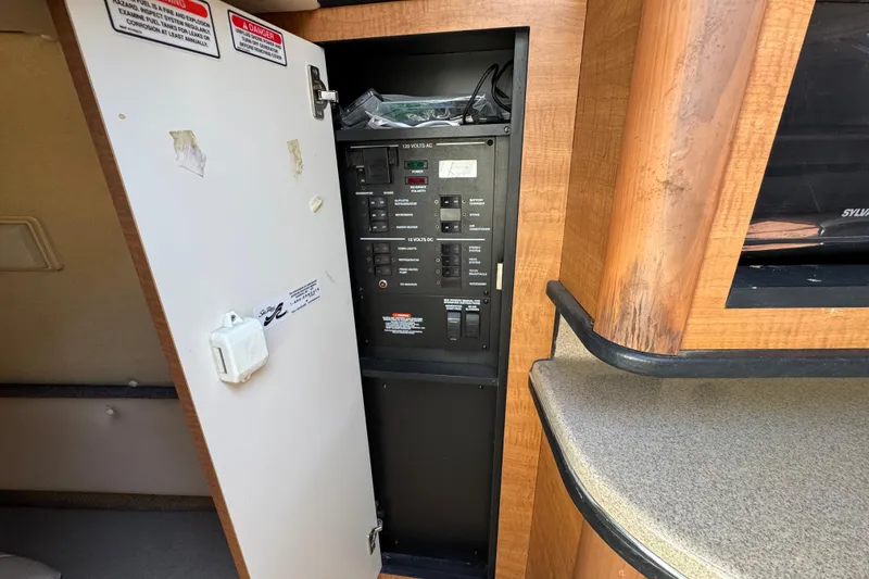 Slide: The Image of Electrical panel inside 2006 Sea Ray Sundancer 260 boat cabin with open door. - 30