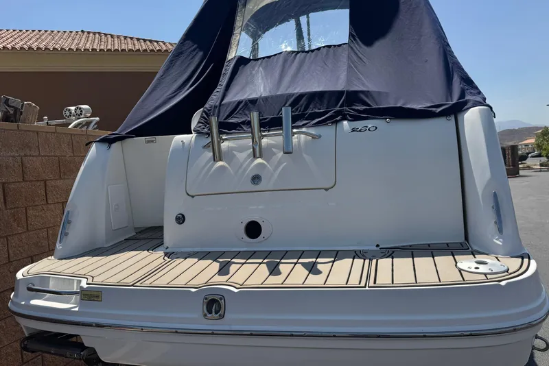 Slide: The Image of 2006 Sea Ray Sundancer 260 boat with covered cockpit, docked outdoors. - 6