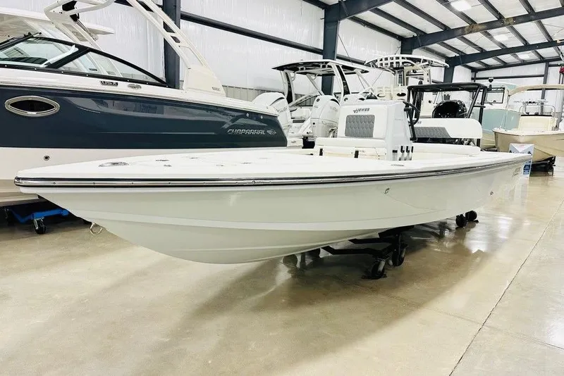 The Image of 2026 Hewes Redfisher 18 boat displayed in a showroom, side view. - 1