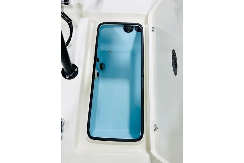 Slide: The Image of Open storage compartment on 2026 Hewes Redfisher 18 boat, featuring a light blue interior. - 9