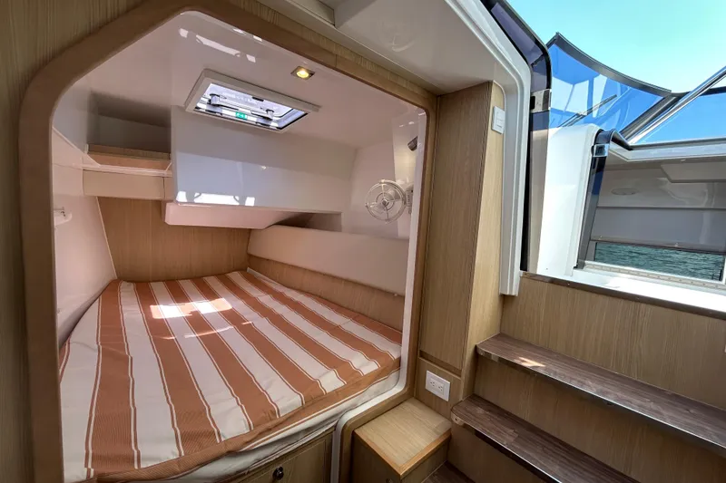 Slide: The Image of Cozy cabin interior of 2020 Aquila 36 Sport yacht with striped bedding and natural light. - 15