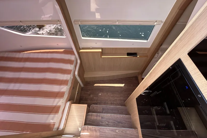 Slide: The Image of Interior of 2020 Aquila 36 Sport yacht with striped bedding and wooden finishes. - 18