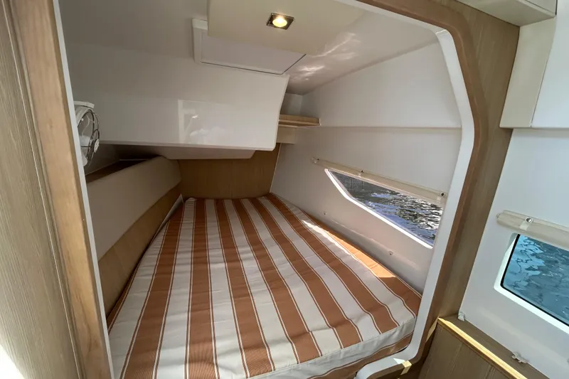 Slide: The Image of Cozy cabin interior of 2020 Aquila 36 Sport with striped bedding and window view. - 19