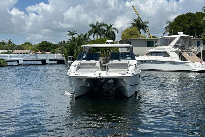 Slide: The Image of 2020 Aquila 36 Sport catamaran docked on a sunny day with palm trees in the background. - 3