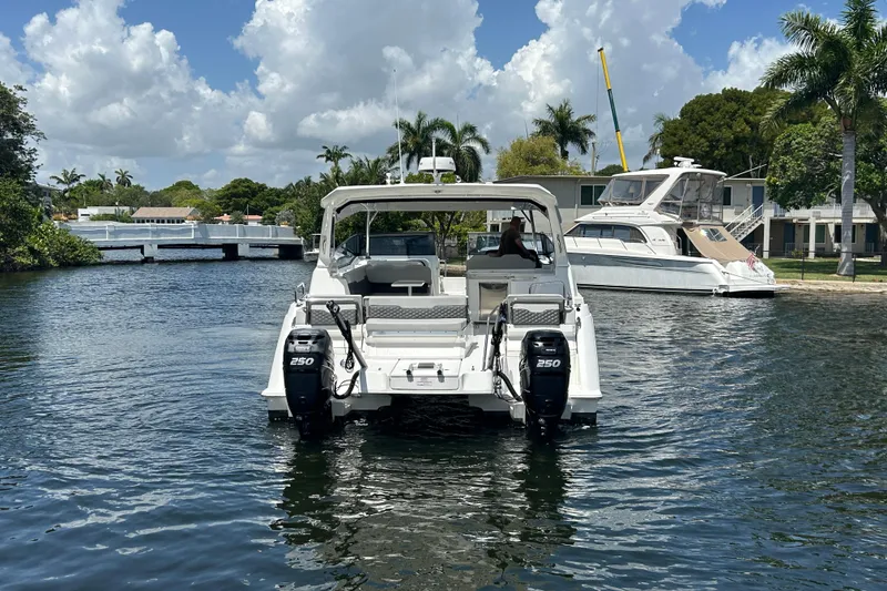 Slide: The Image of 2020 Aquila 36 Sport boat on a scenic waterway with palm trees and blue sky. - 4