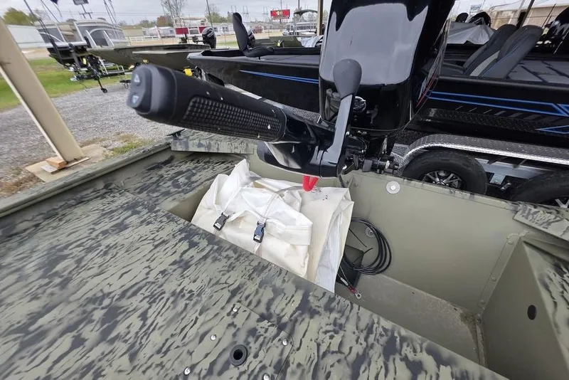 Slide: The Image of 2026 Tracker Grizzly 1754 Utility boat interior with motor and storage compartment. - 6