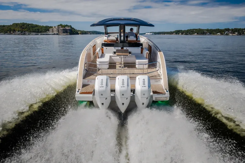 Slide: The Image of 2025 Invictus TT430 yacht cruising on a scenic lake with powerful engines. - 16