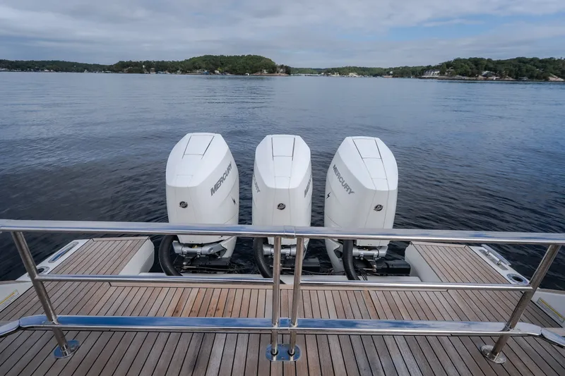 Slide: The Image of 2025 Invictus TT430 yacht with triple Mercury outboard engines on a serene lake. - 18