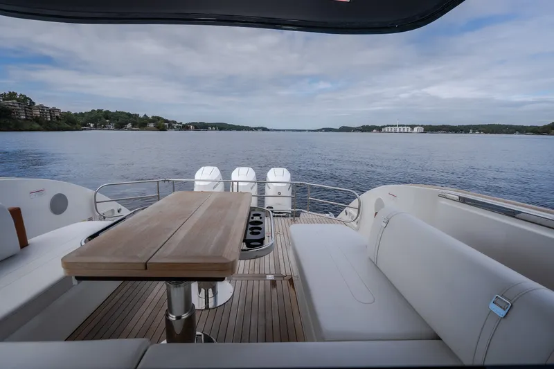 Slide: The Image of Luxurious 2025 Invictus TT430 yacht deck with seating, overlooking serene waters and scenic shoreline. - 62