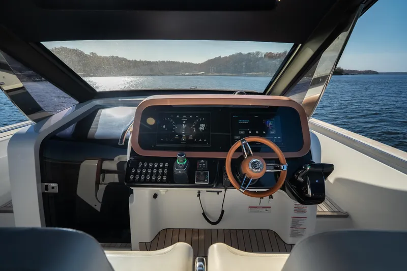 Slide: The Image of Interior view of 2025 Invictus TT430 yacht cockpit with modern controls and scenic water backdrop. - 21
