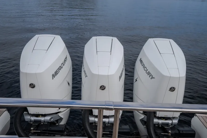 Slide: The Image of Triple Mercury outboard engines on 2025 Invictus TT430 boat, docked on calm water. - 19