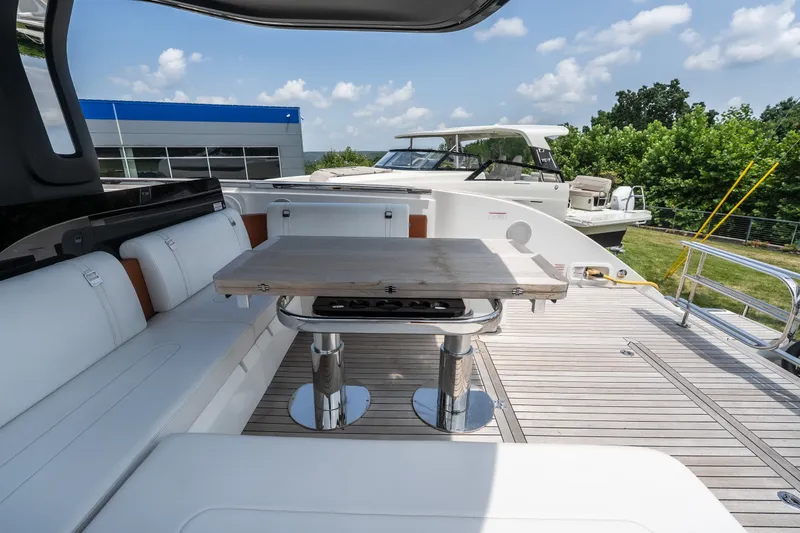 Slide: The Image of Luxurious 2025 Invictus TT430 yacht deck with seating and table, under a clear blue sky. - 15