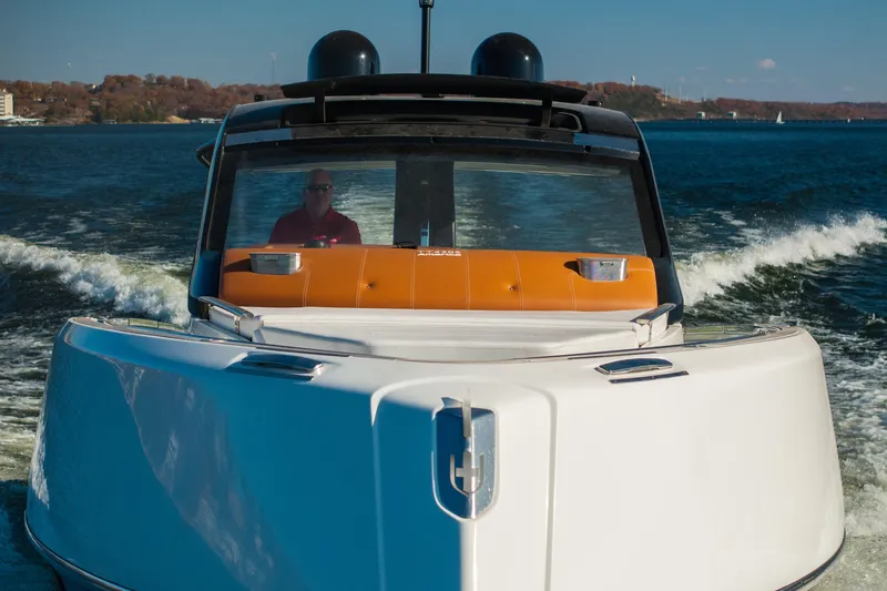 Slide: The Image of 2025 Invictus TT430 yacht cruising on a sunny day, with a person at the helm. - 3