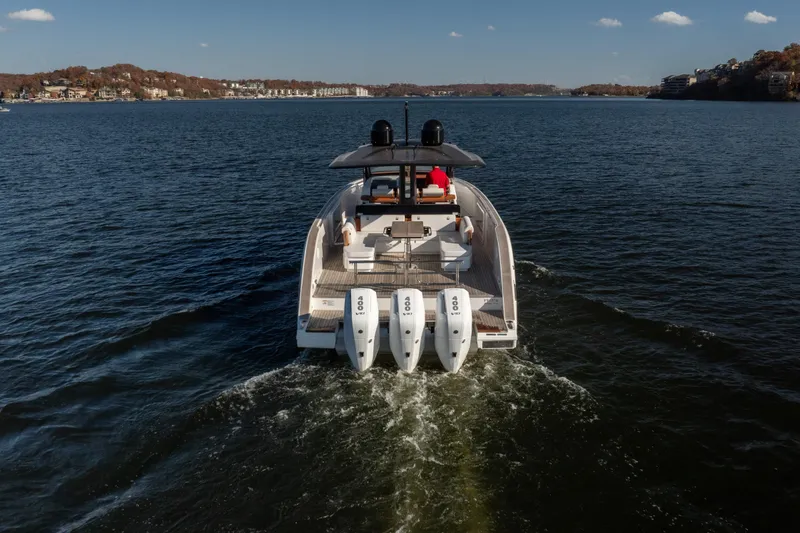 Slide: The Image of 2025 Invictus TT430 yacht cruising on a serene lake with triple outboard engines. - 31