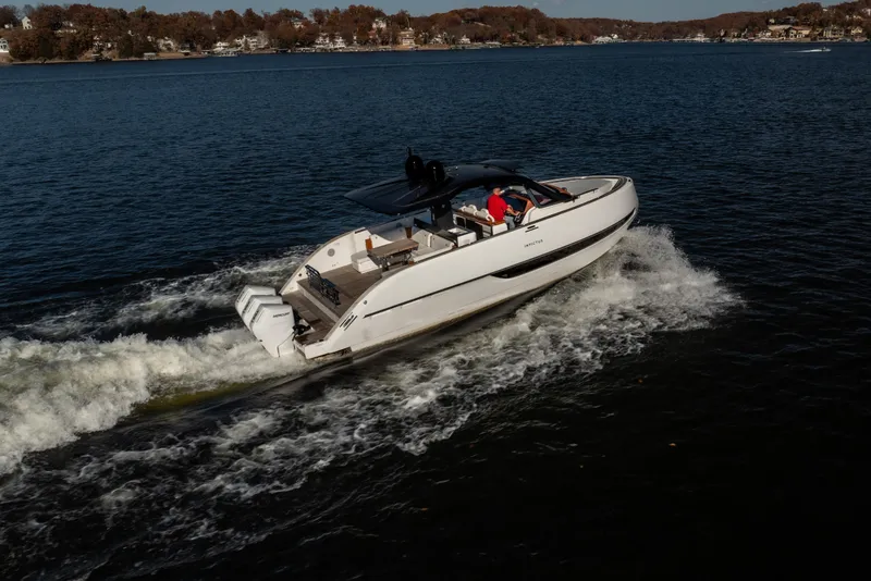Slide: The Image of 2025 Invictus TT430 yacht cruising on a serene lake with scenic shoreline. - 32