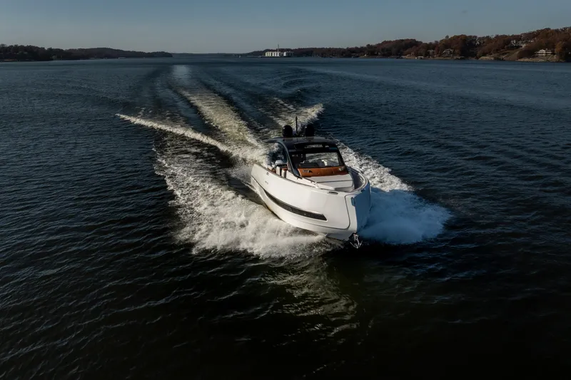 Slide: The Image of 2025 Invictus TT430 yacht cruising on a serene lake under clear skies. - 33