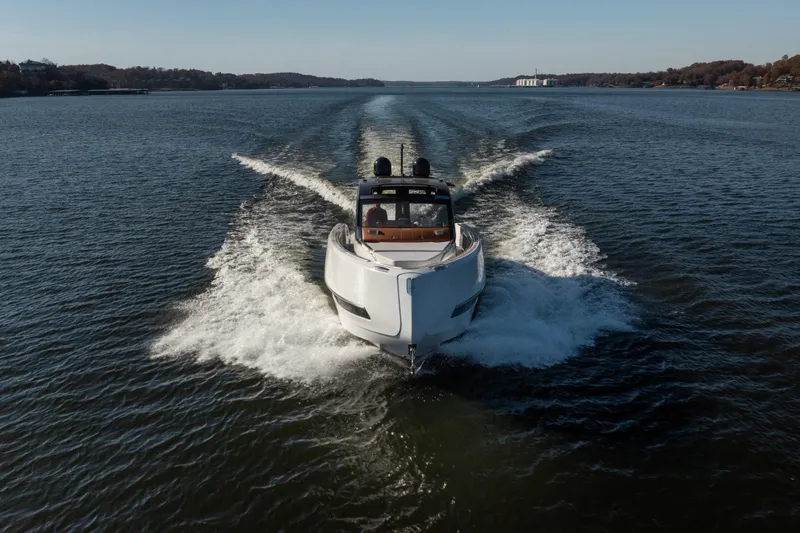 Slide: The Image of 2025 Invictus TT430 yacht cruising on a serene lake, creating a dynamic water trail. - 34