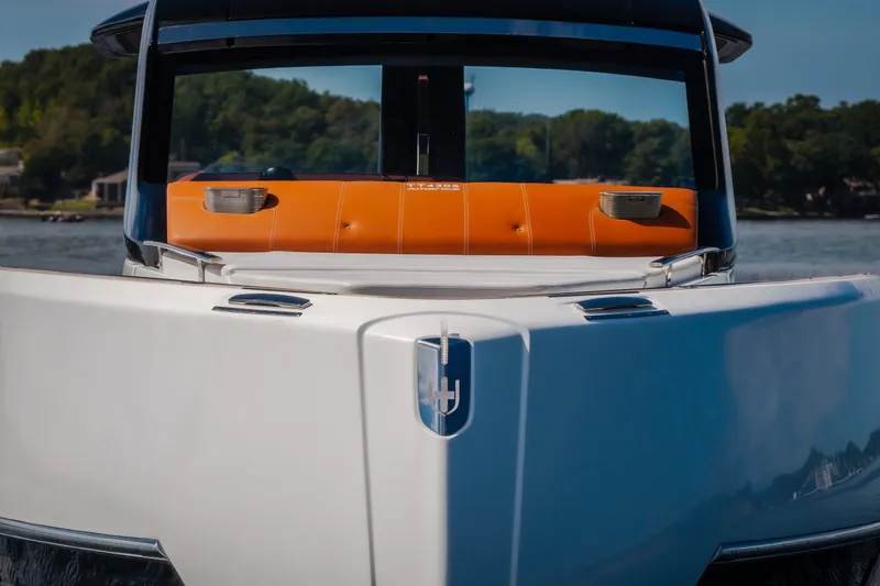 Slide: The Image of 2025 Invictus TT430 yacht with sleek design and orange seating, on a serene lake. - 99