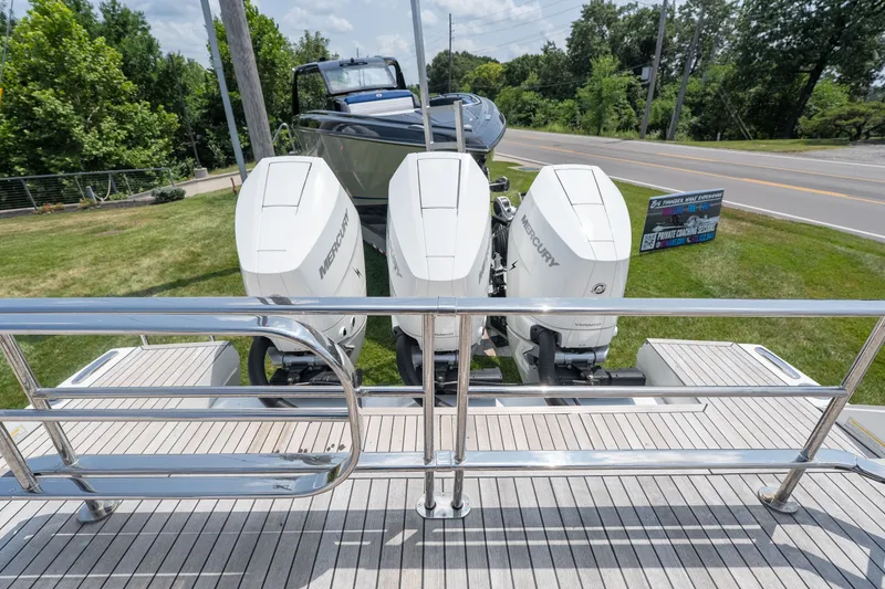 Slide: The Image of Triple Mercury outboard engines on a 2025 Invictus TT430 boat, parked on a grassy area. - 12