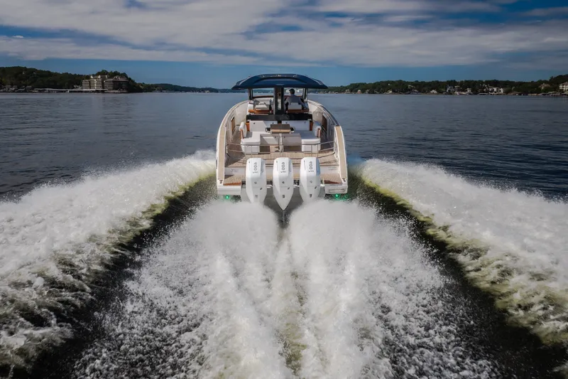 Slide: The Image of 2025 Invictus TT430 yacht cruising on a serene lake, showcasing powerful engines and elegant design. - 102