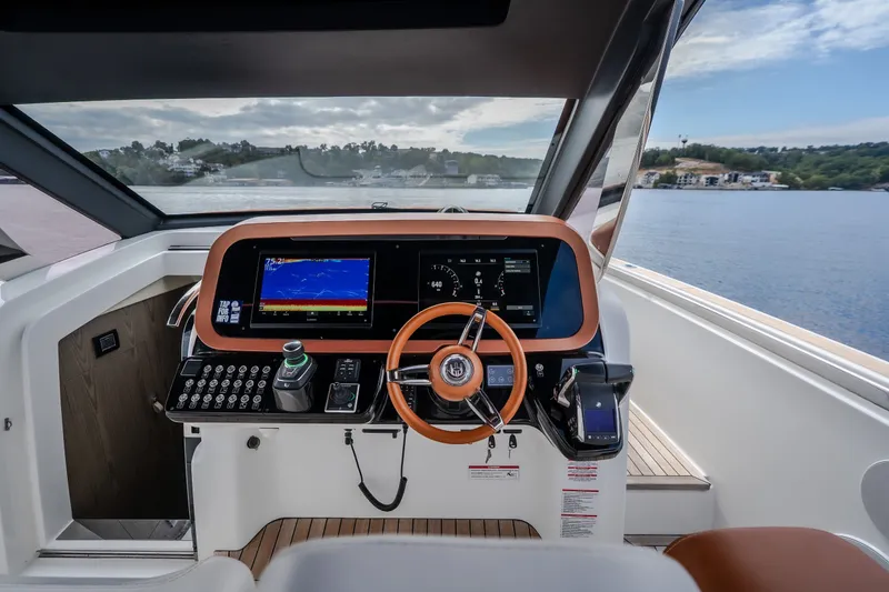 Slide: The Image of Cockpit of 2025 Invictus TT430 yacht with modern navigation controls and scenic water view. - 43