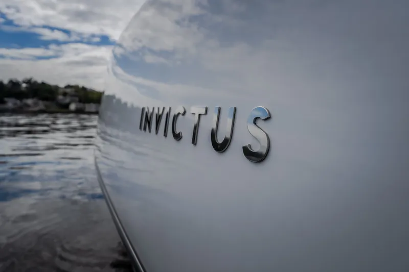 Slide: The Image of 2025 Invictus TT430 boat side view with logo, reflecting on water. - 33