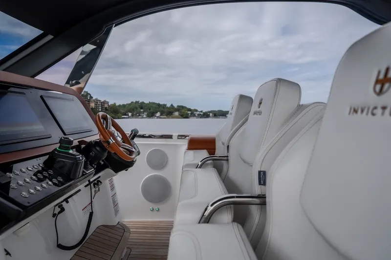 Slide: The Image of Interior of 2025 Invictus TT430 yacht with luxurious seating and modern dashboard. - 68