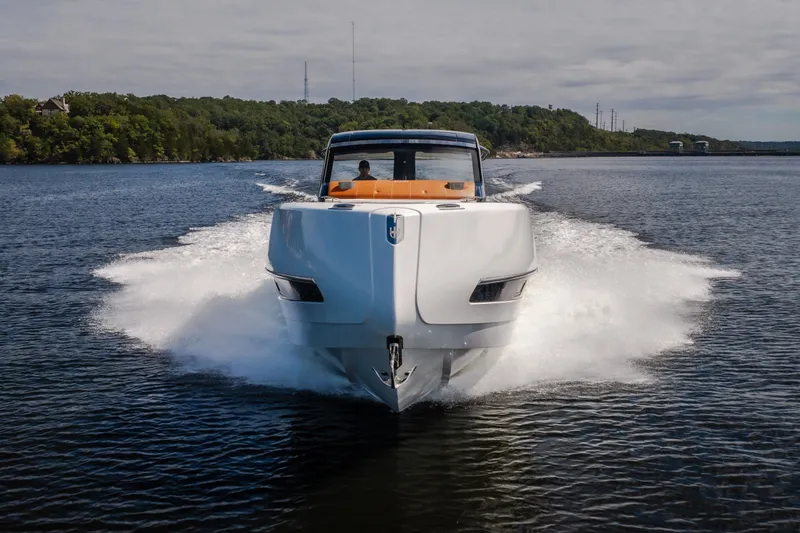 Slide: The Image of 2025 Invictus TT430 yacht cruising on a scenic lake with lush green shoreline. - 101