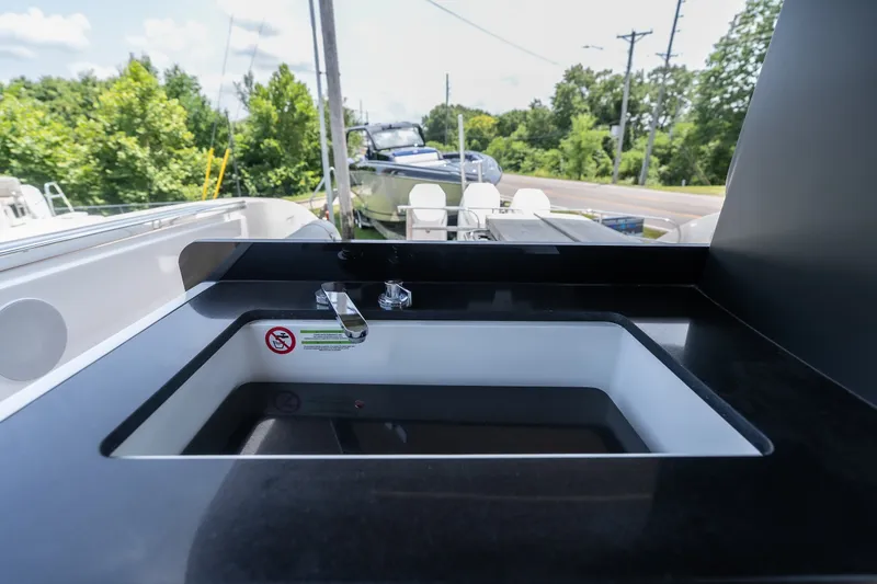 Slide: The Image of 2025 Invictus TT430 boat sink with sleek black countertop, outdoor setting. - 25