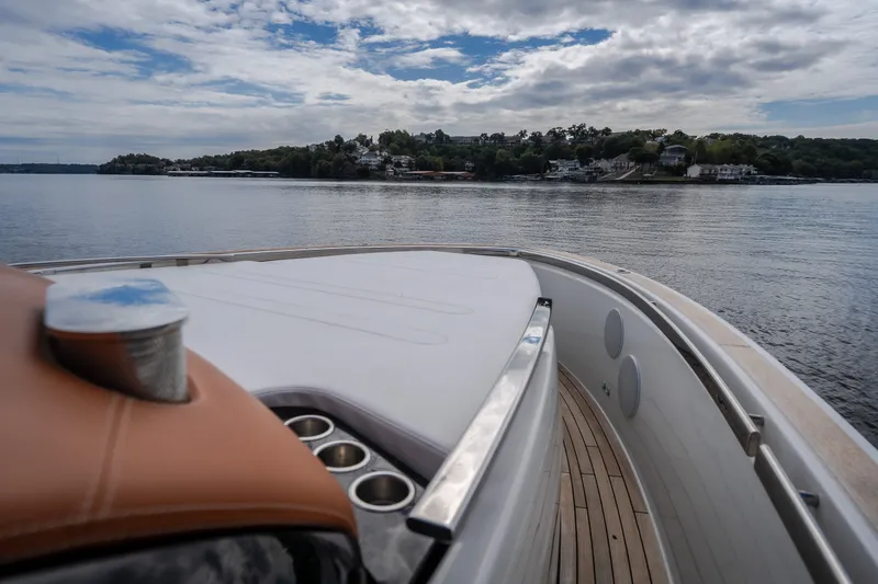 Slide: The Image of 2025 Invictus TT430 yacht cruising on a serene lake with scenic shoreline views. - 59