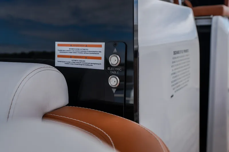 Slide: The Image of Interior detail of 2025 Invictus TT430, featuring electric table controls and leather seating. - 21