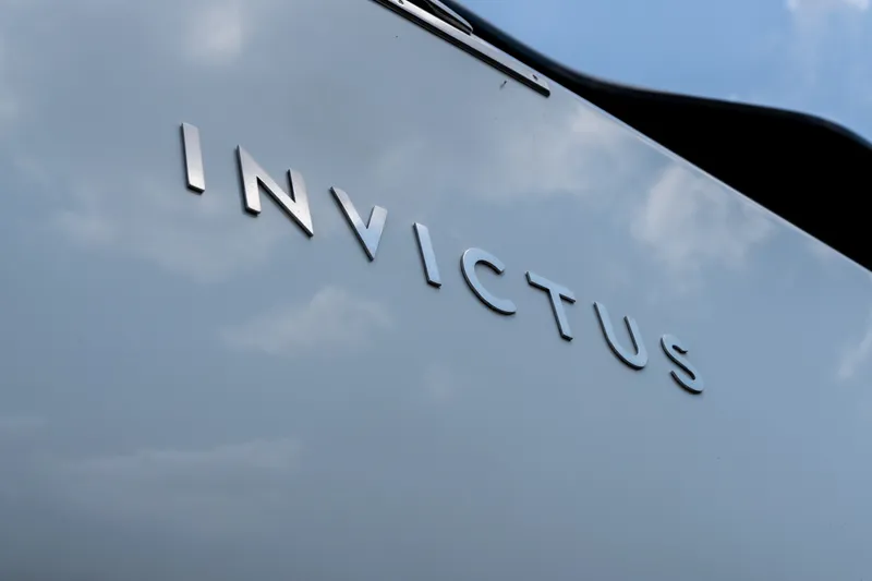 Slide: The Image of Invictus TT430 2025 logo on sleek surface under blue sky. - 3