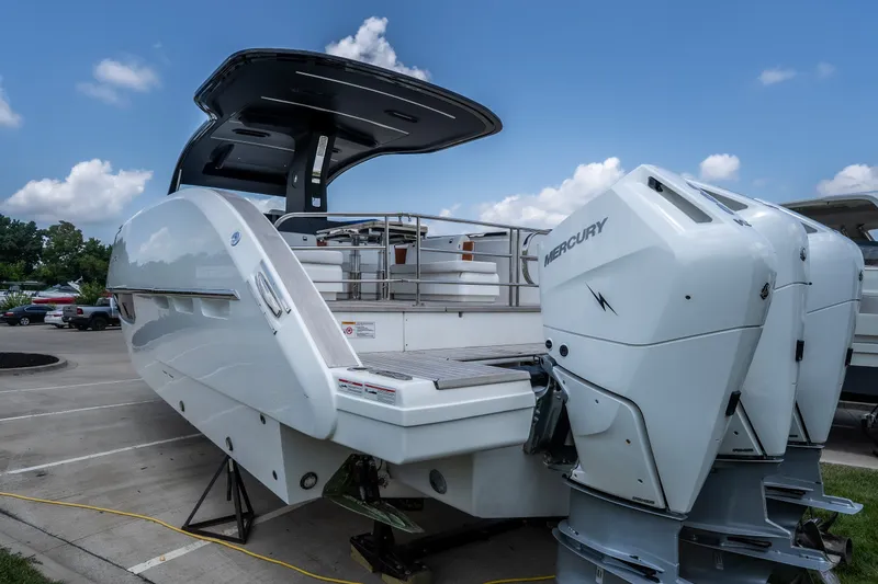 Slide: The Image of 2025 Invictus TT430 boat with Mercury engines, docked under a clear blue sky. - 4