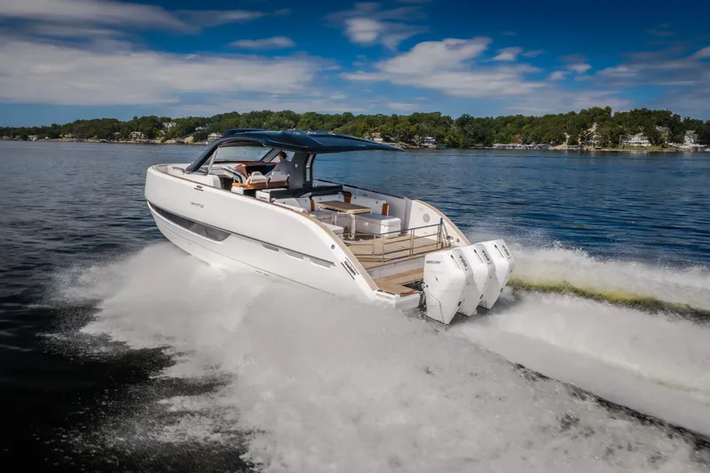 Slide: The Image of 2025 Invictus TT430 boat cruising on a lake with triple outboard engines. - 103