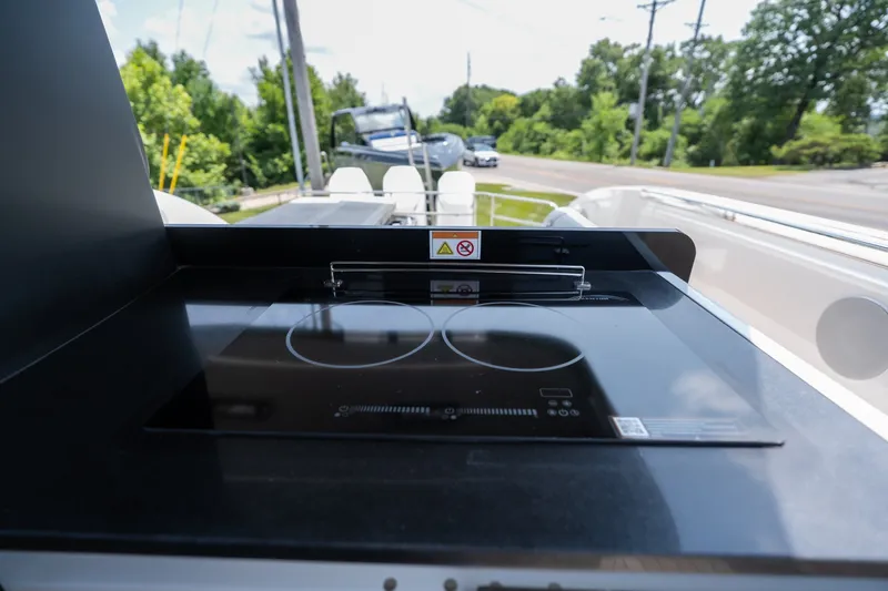 Slide: The Image of Modern induction cooktop on 2025 Invictus TT430 yacht, surrounded by lush greenery. - 27