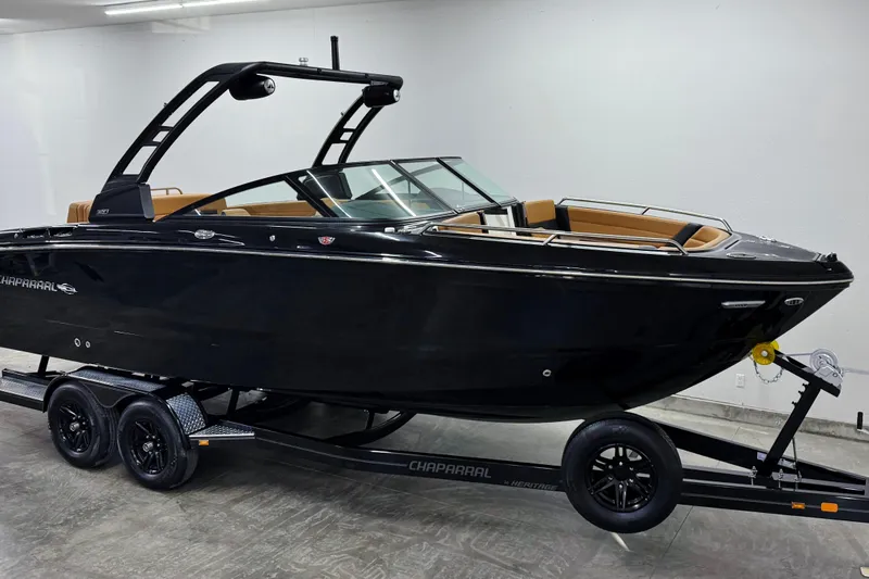 Slide: The Image of 2026 Chaparral SSX 6 boat on trailer in showroom, sleek black design. - 2