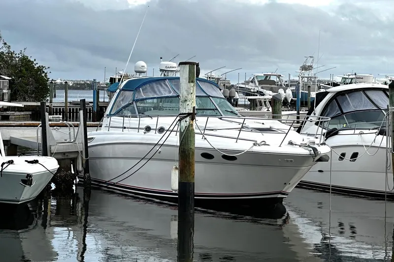 The Image of 2001 Sea Ray 380 Sundancer yacht docked at marina under cloudy skies. - 0