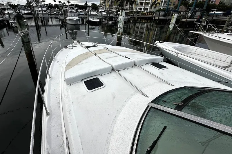Slide: The Image of 2001 Sea Ray 380 Sundancer docked at marina, view of bow and surrounding boats. - 10