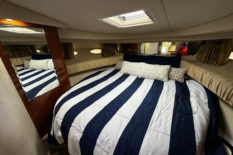 Slide: The Image of Luxurious cabin interior of 2001 Sea Ray 380 Sundancer with striped bedding and elegant decor. - 22