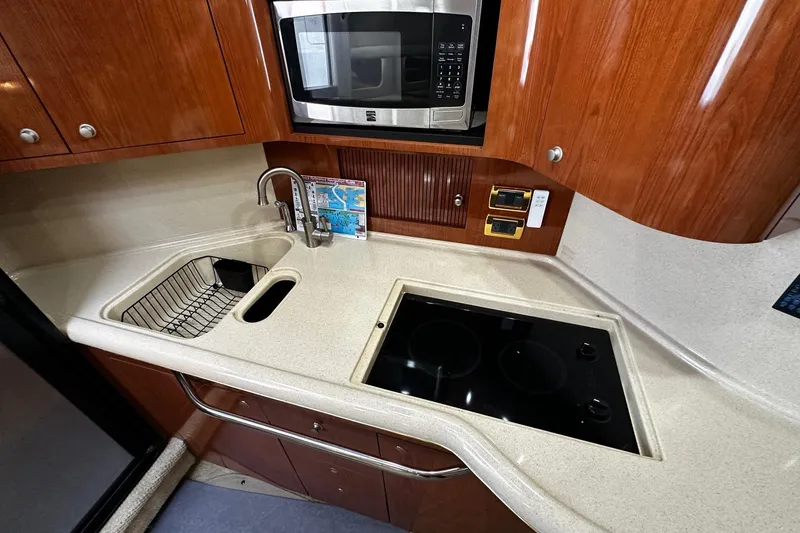 Slide: The Image of 2001 Sea Ray 380 Sundancer galley with sink, stovetop, and microwave. - 29