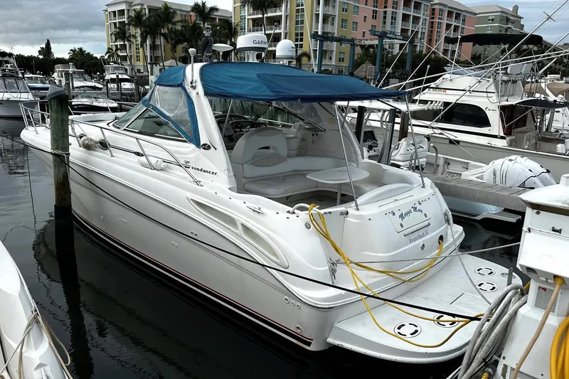 Slide: The Image of 2001 Sea Ray 380 Sundancer docked at marina, featuring blue canopy and white hull. - 7