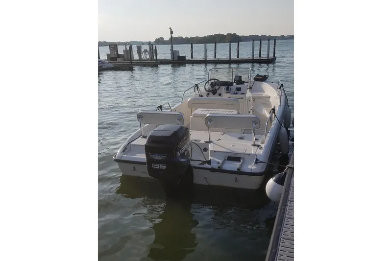 Slide: The Image of 1999 Boston Whaler 180 Dauntless boat docked on calm water. - 13