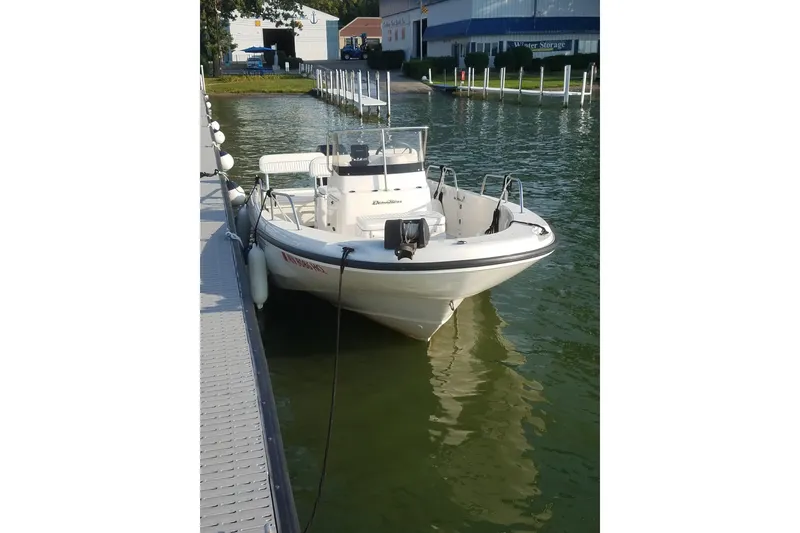 Slide: The Image of 1999 Boston Whaler 180 Dauntless boat docked on calm water. - 14